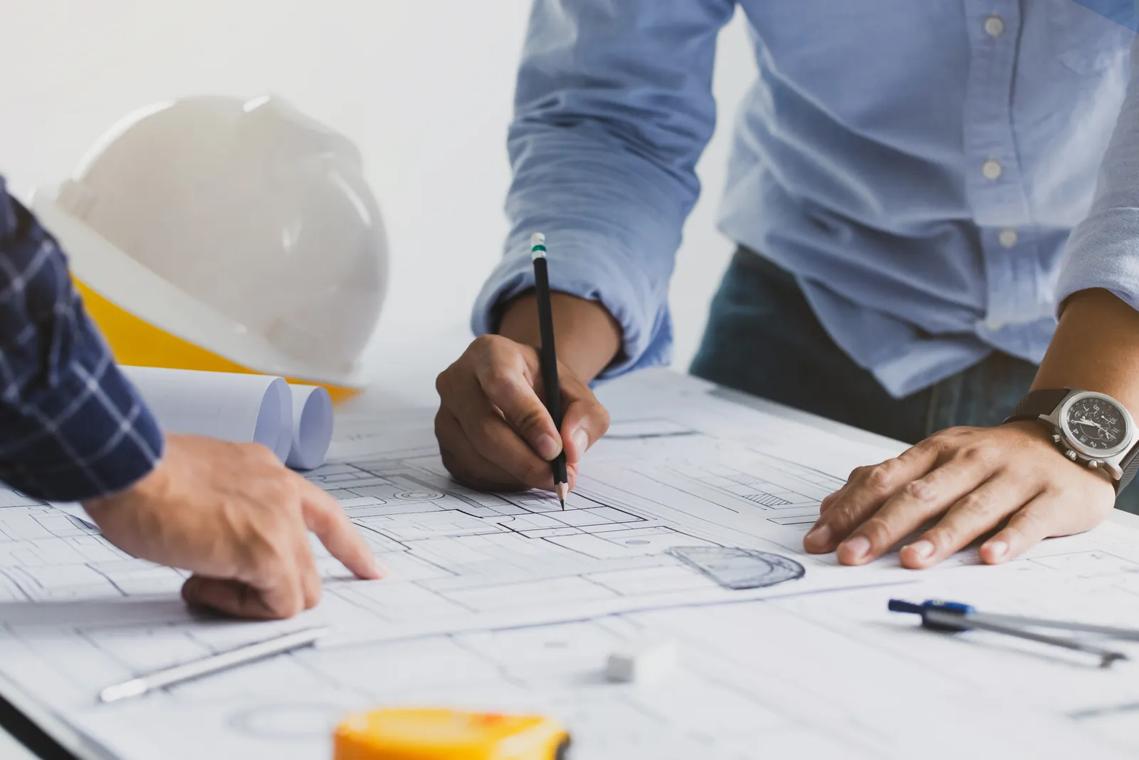 Design professionals marking and reviewing architectural blueprints.